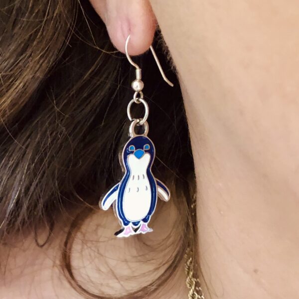 model wearing penguin earring